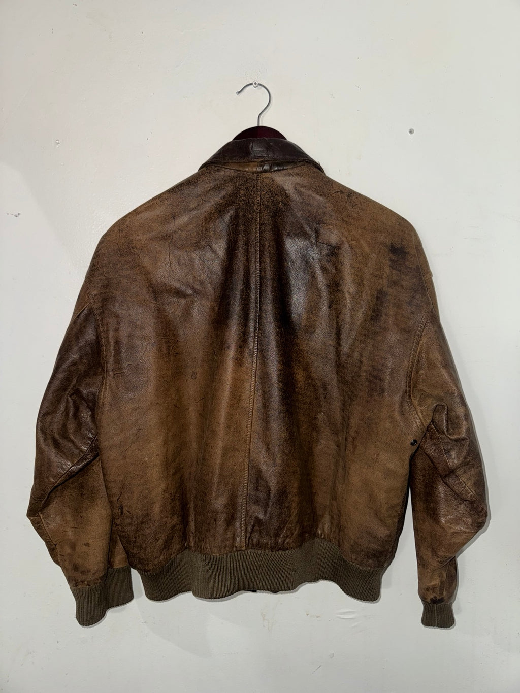 Distressed brown leather bomber jacket back view
