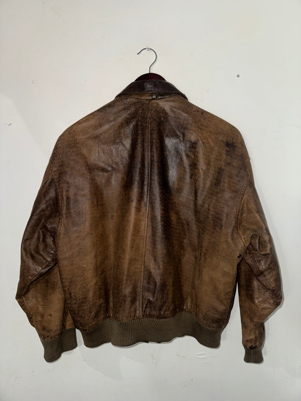 Distressed brown leather bomber jacket back view