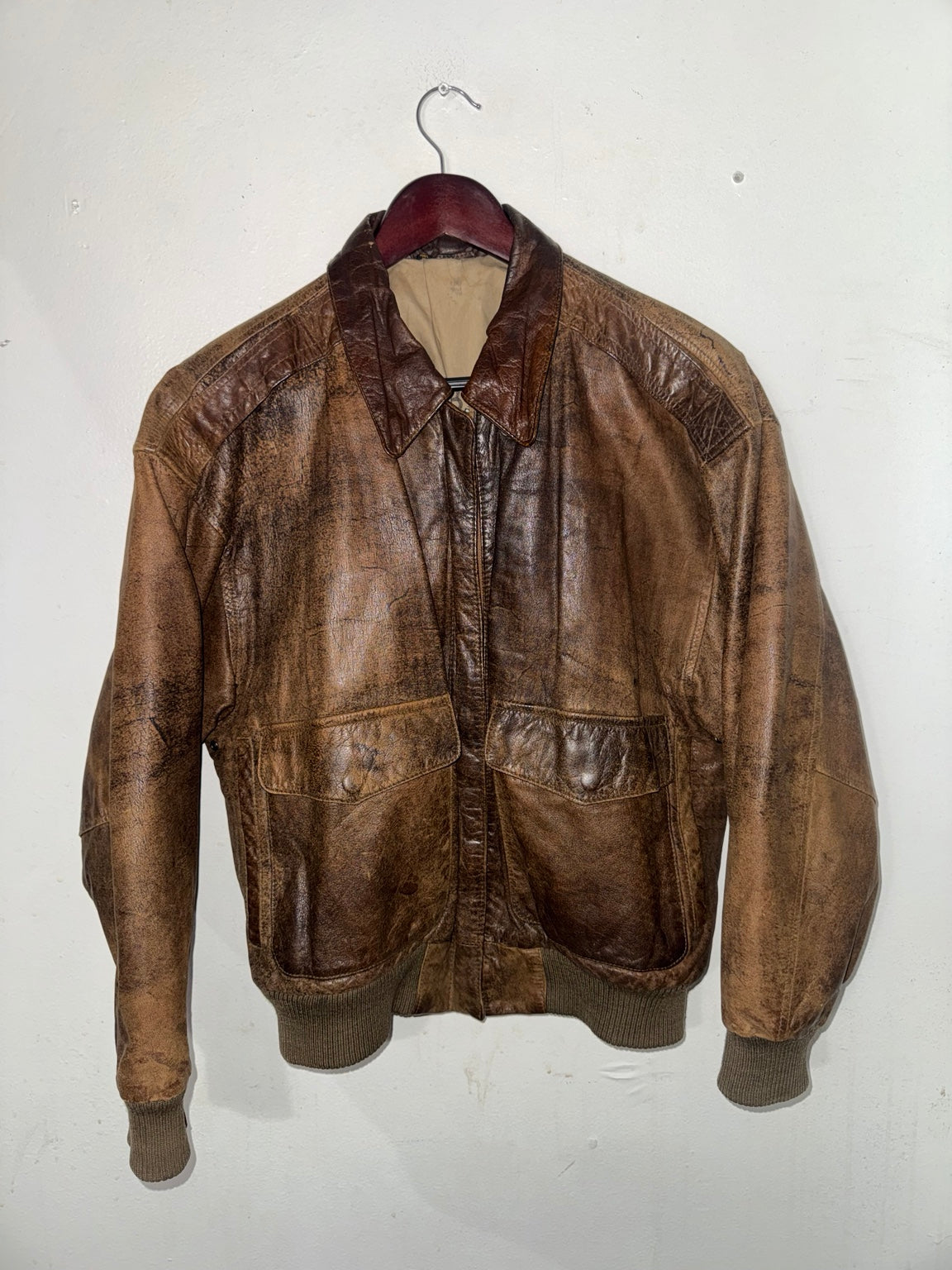 Distressed brown leather bomber jacket front view